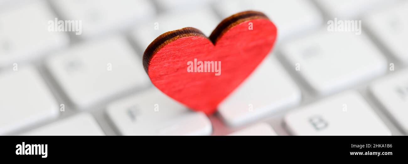 Small red heart on computer keyboard closeup Stock Photo