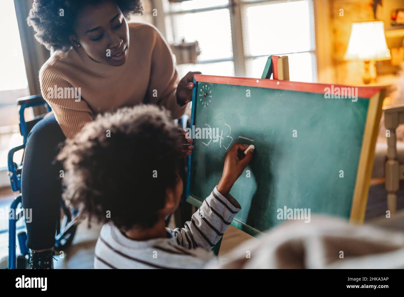 Happy woman with disability learning together with a child. People education fun concept Stock Photo