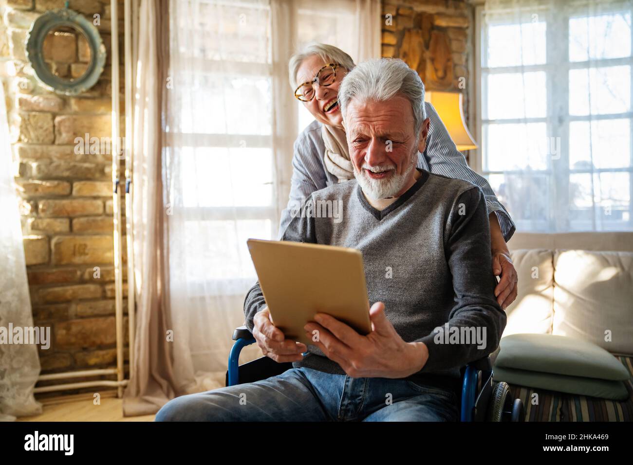 Senior couple having fun and laughing while using their tablet pc computer. Stock Photo