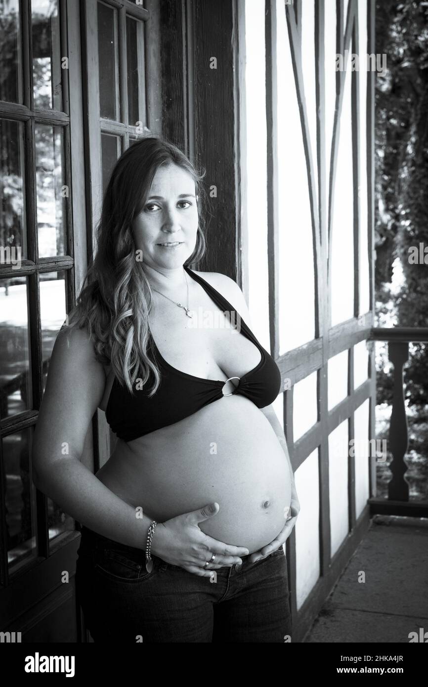 Seven months pregnant young woman dressed in black bikini and jeans Stock  Photo - Alamy