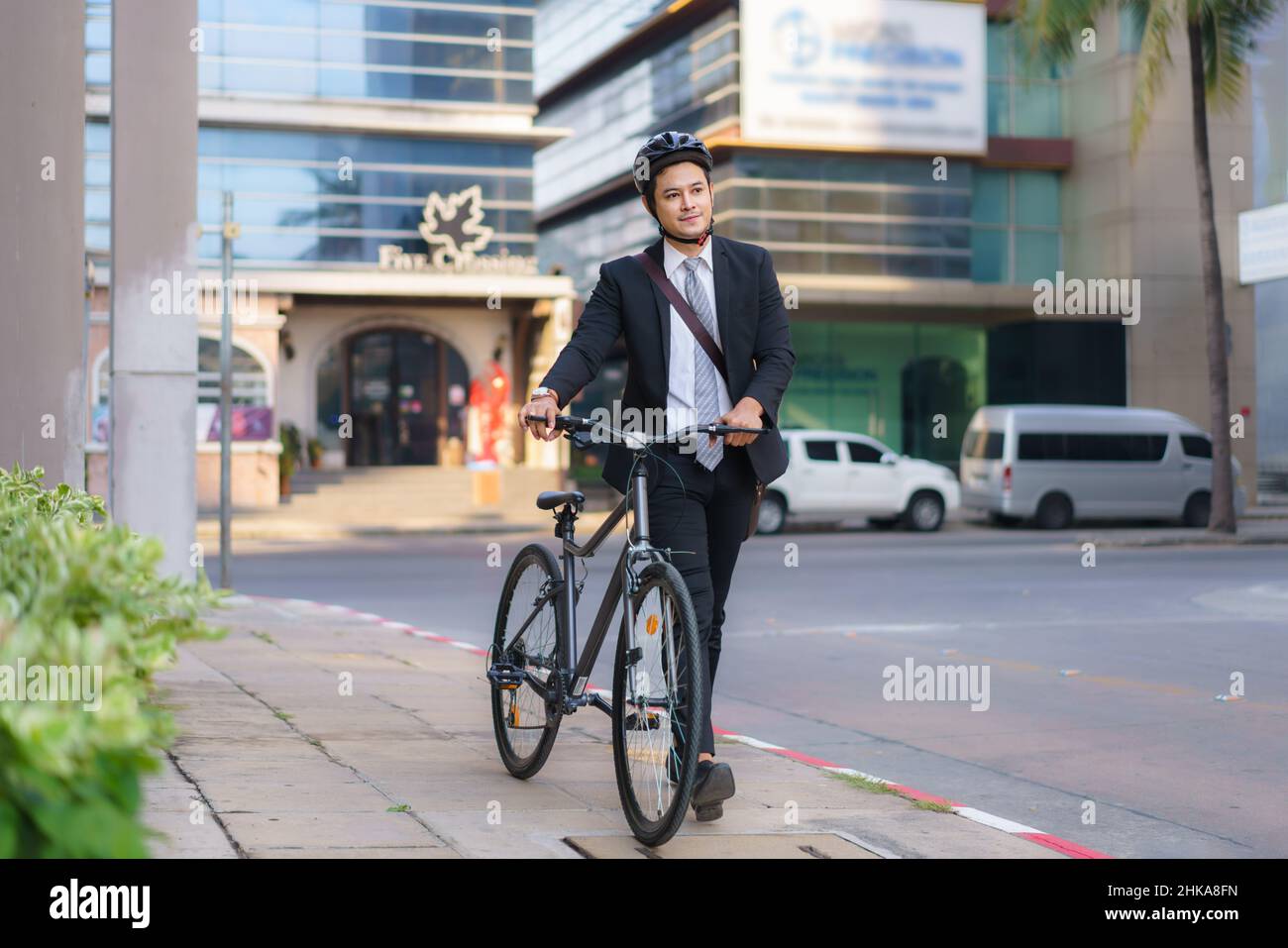 Asian businessman pushing his bicycle from home in the morning preparing to ride his bicycle to work. Eco tranportation. Stock Photo