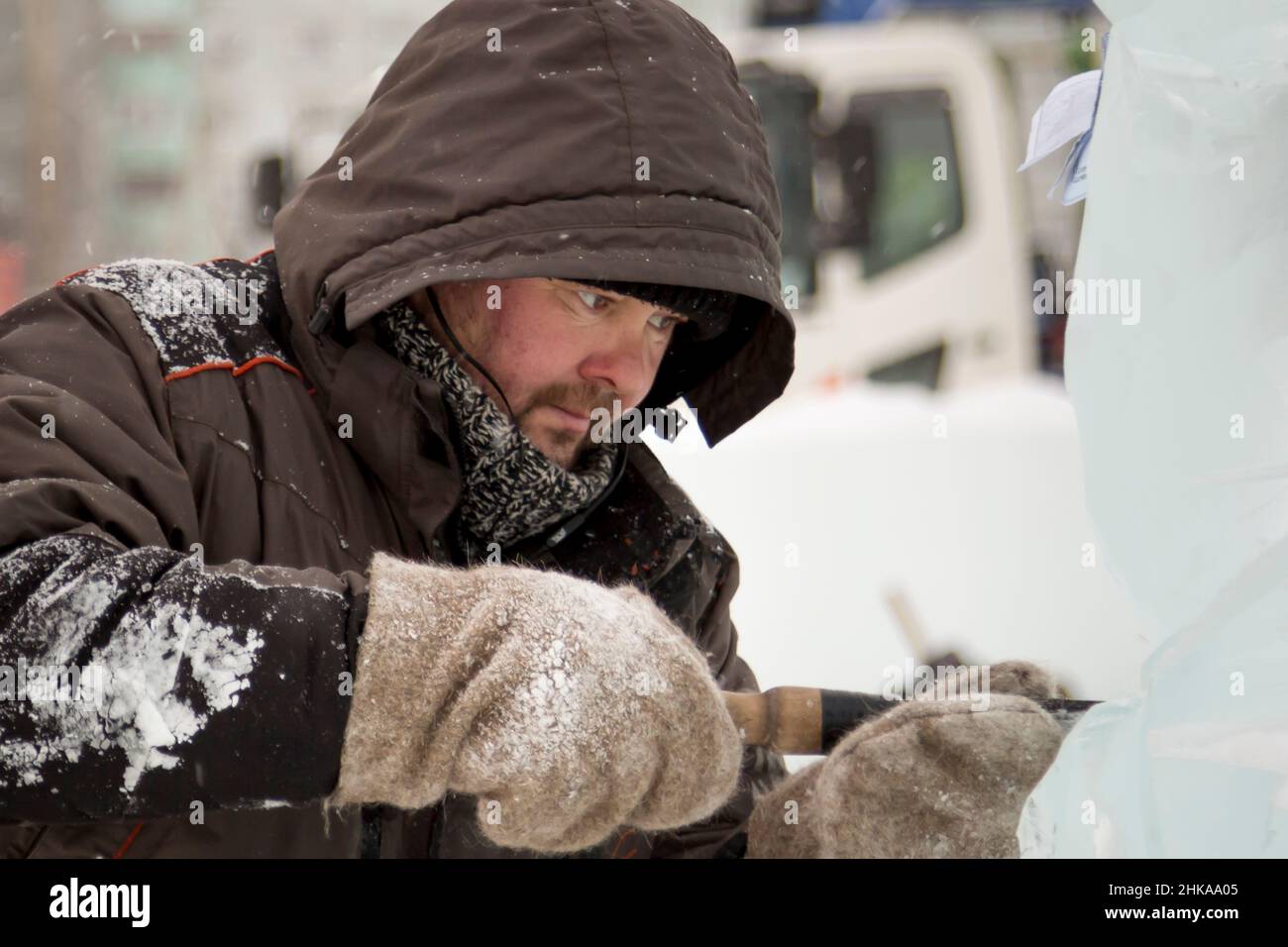The sculptor cuts an ice figure out of an ice block with a chisel Stock ...
