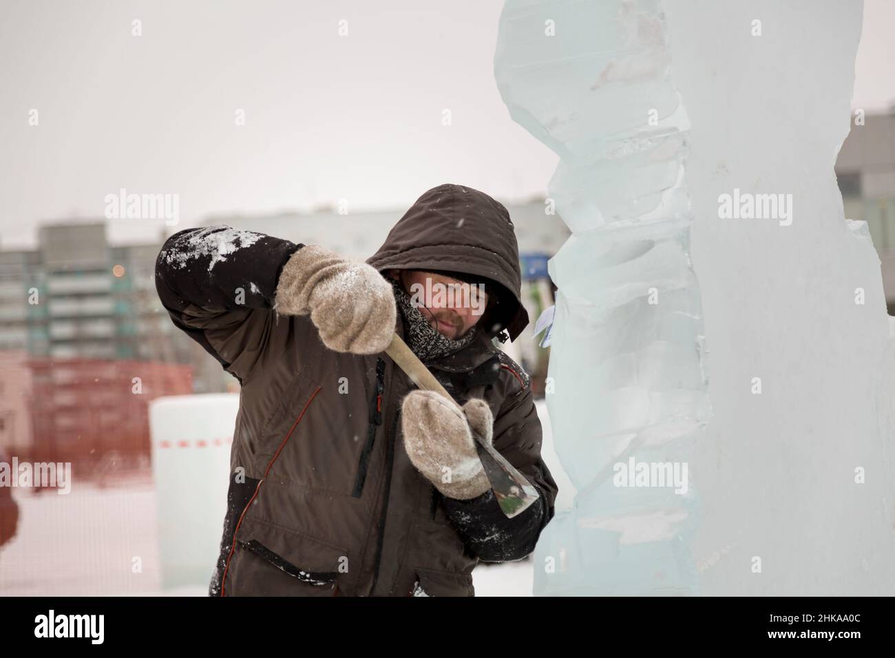 The sculptor cuts an ice figure out of an ice block with a chisel Stock ...