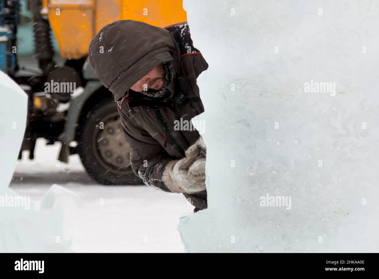 The sculptor cuts an ice figure out of an ice block with a chisel Stock ...