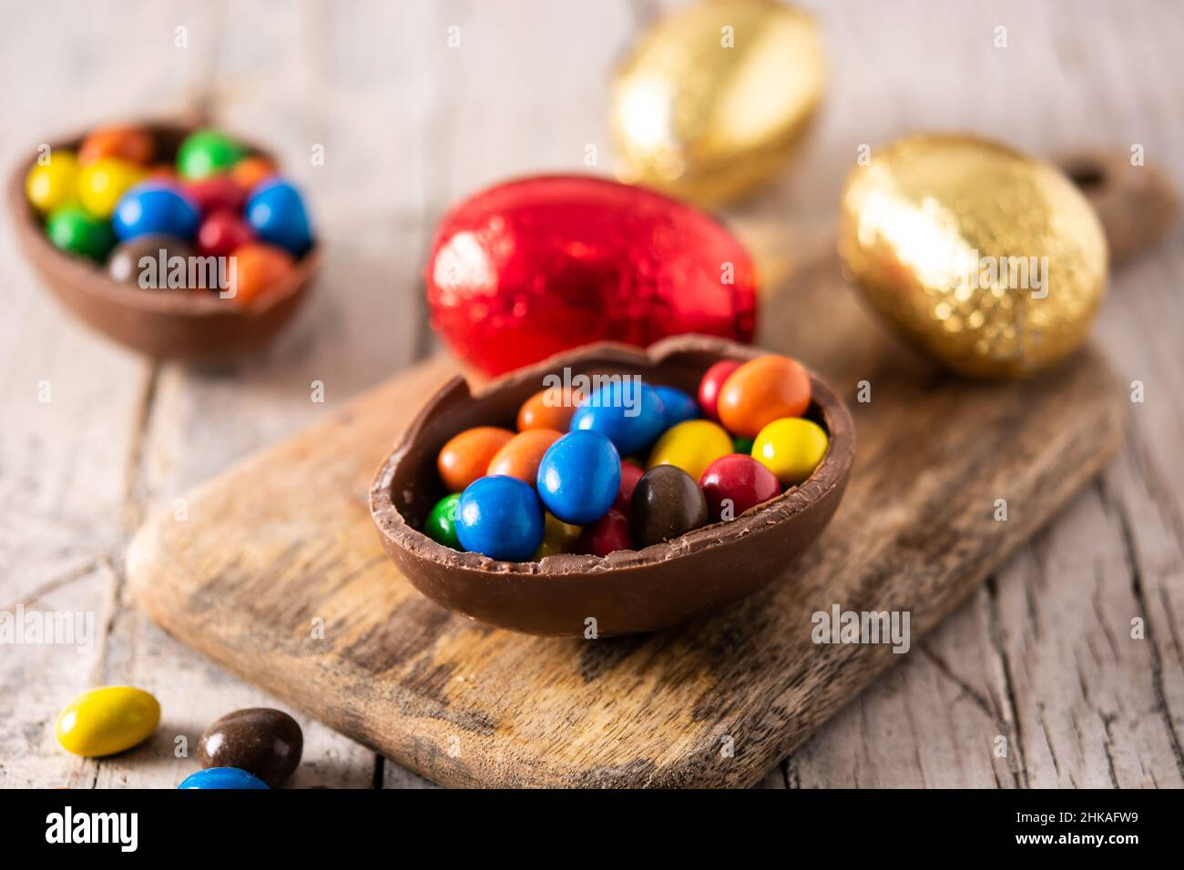 Colorful chocolate Easter eggs on wooden table Stock Photo