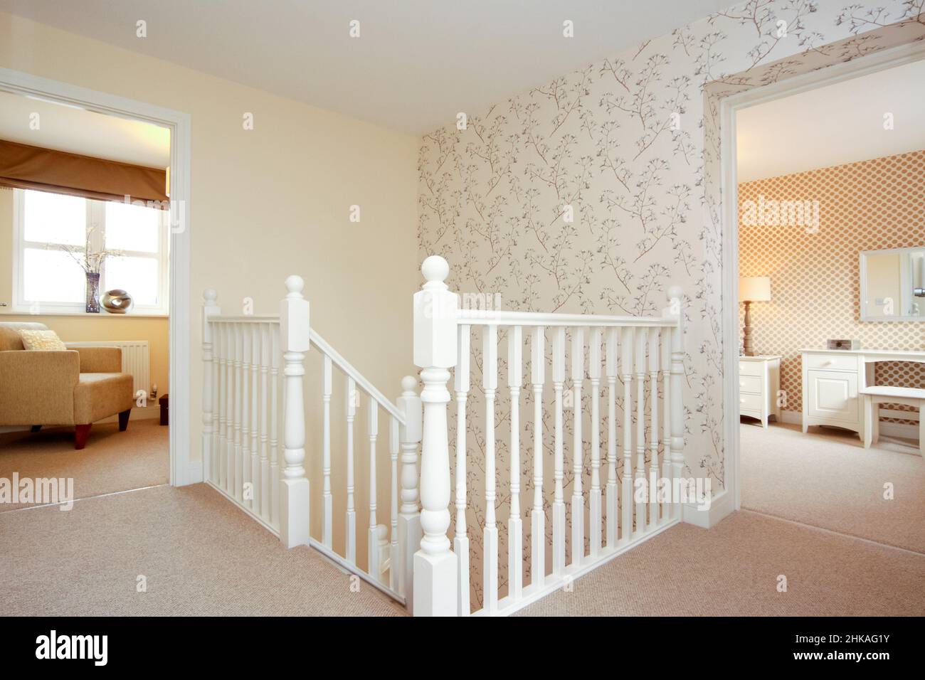 Landing in a modern house, view across stairs and bannister into two bedrooms, feature wall. Stock Photo
