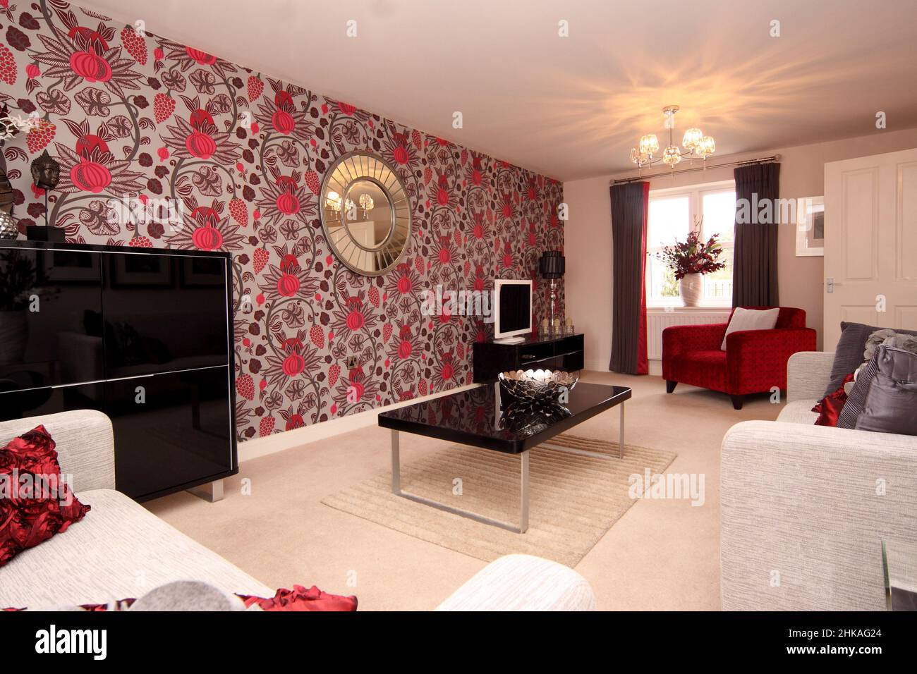 Living room lounge in dramatic black red and white colour color scheme,floral feature wall,dramatic feature wall, new house home. Stock Photo