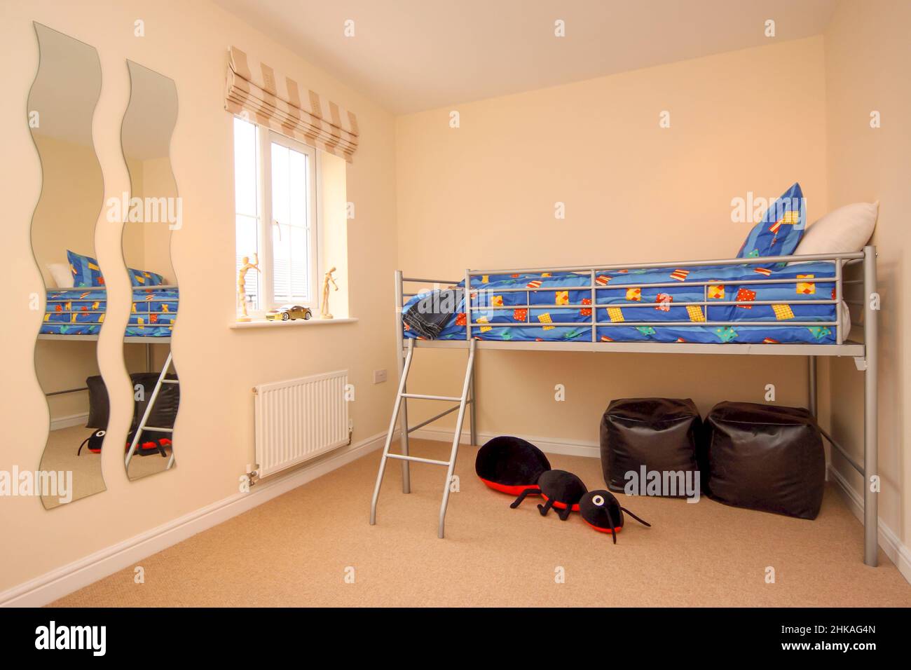 Childs bedroom, raised bed with storage space underneath, bunk bed, bean bags, toy ant. Stock Photo