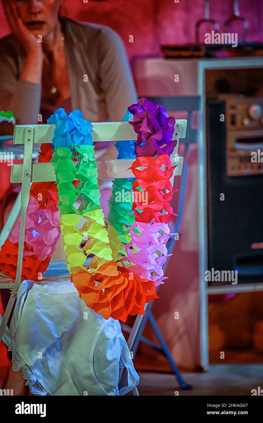 Woman looking depressed at the birthday garland hanging on a chair. Stock Photo