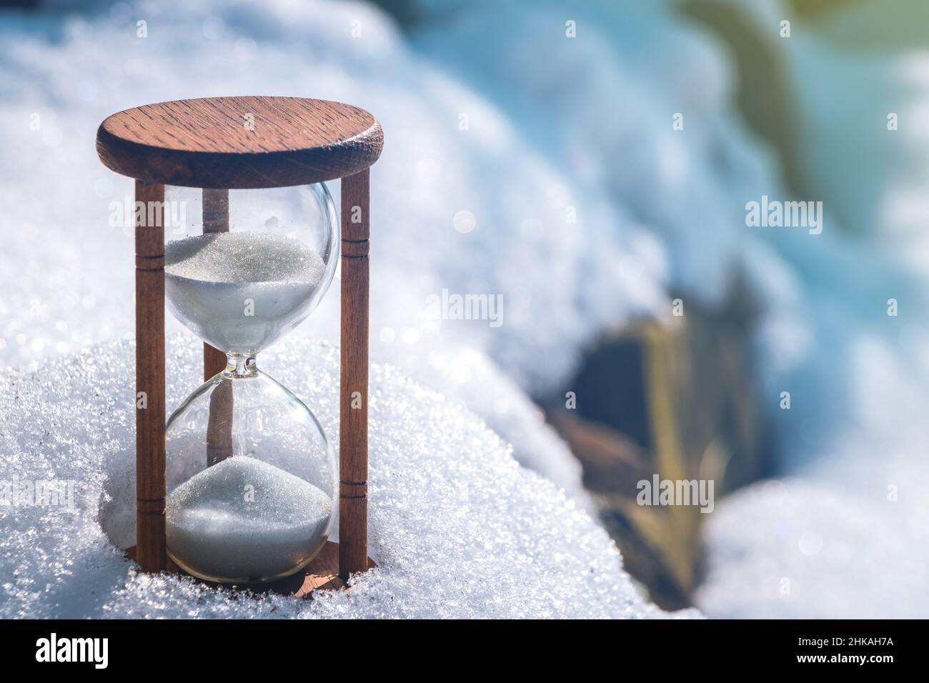 Winter is coming. Hourglass in the snow. Hourglass as a symbol of changing season. Stock Photo