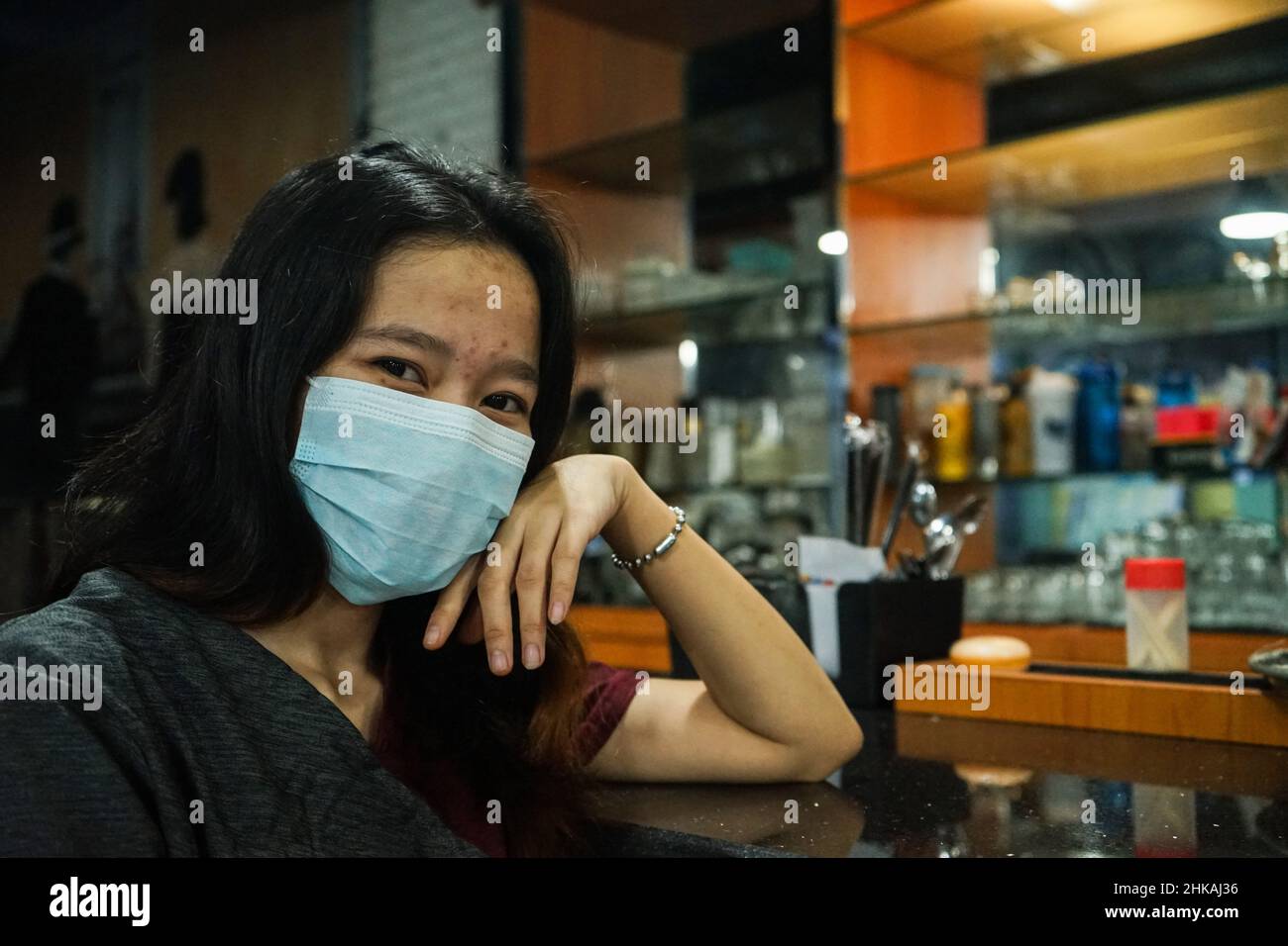 Makassar, South Sulawesi, Indonesia. 3rd Feb, 2022. Portrait of a female cafe employee in Makassar City, Indonesia wearing a mask. The use of masks in Indonesia continues to be encouraged to prevent transmission of the Omicron type of corona virus. (Credit Image: © Herwin Bahar/ZUMA Press Wire) Stock Photo