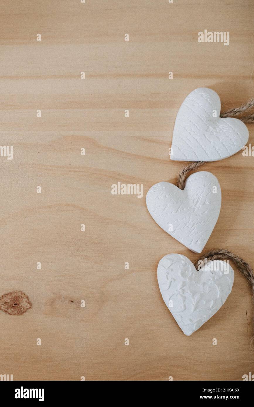 wooden table with a bouquet of flowers and a white heart Stock Photo