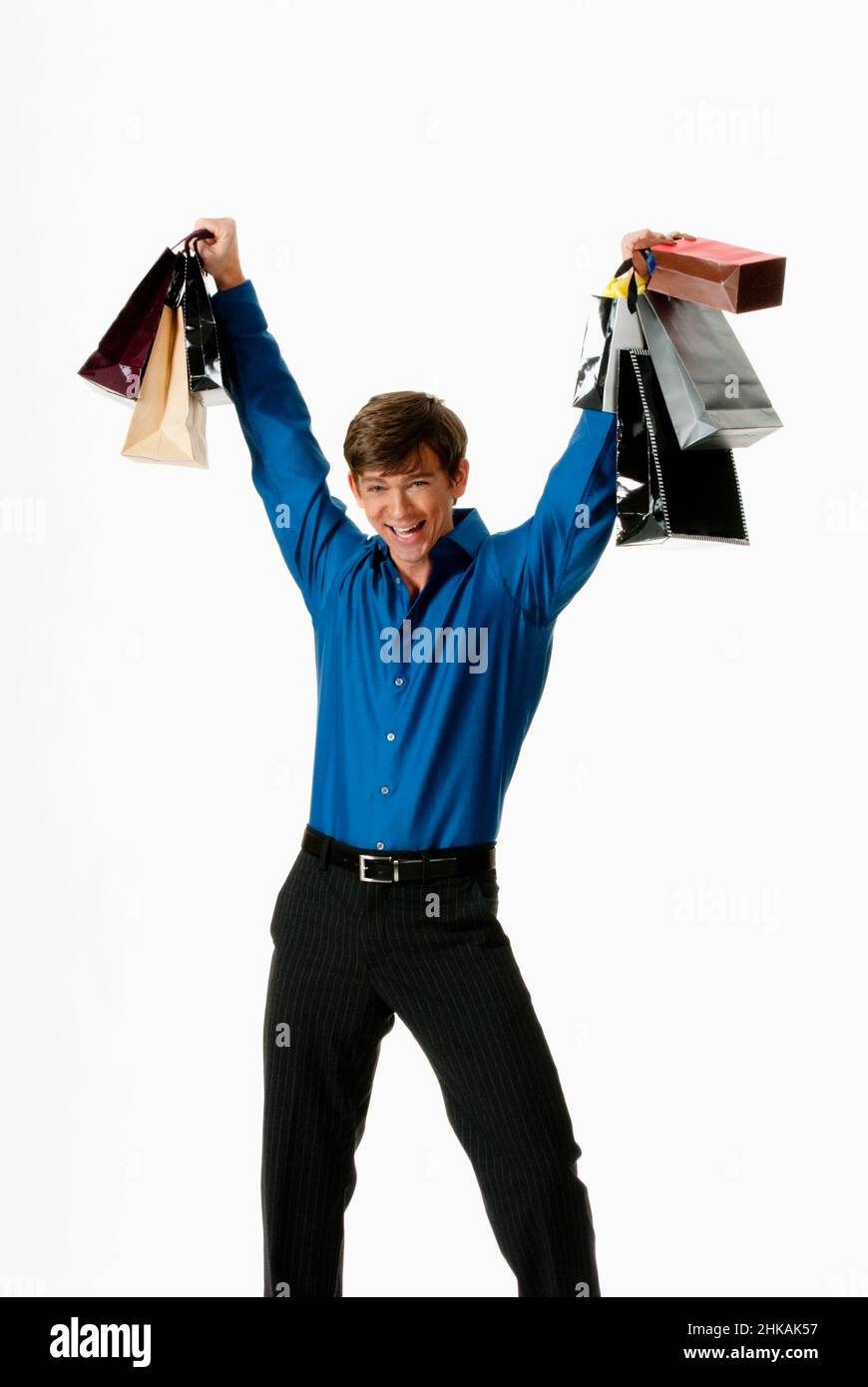Young man holding shopping bags above his head Stock Photo