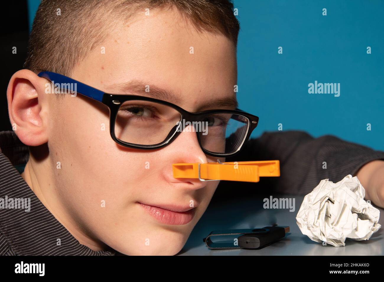 Boy with glasses only face from the front with clothes peg on his nose