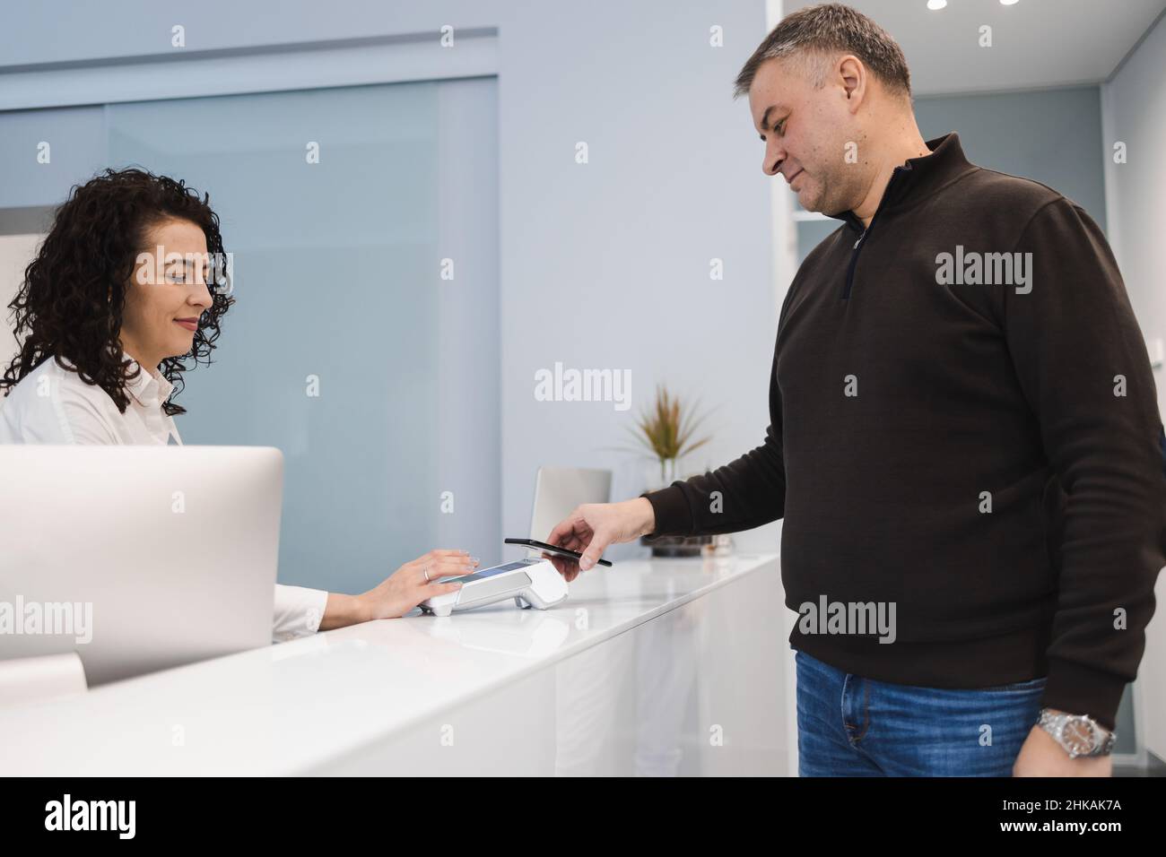 Man pays for services using a smartphone with nfc in a pos terminal Stock Photo