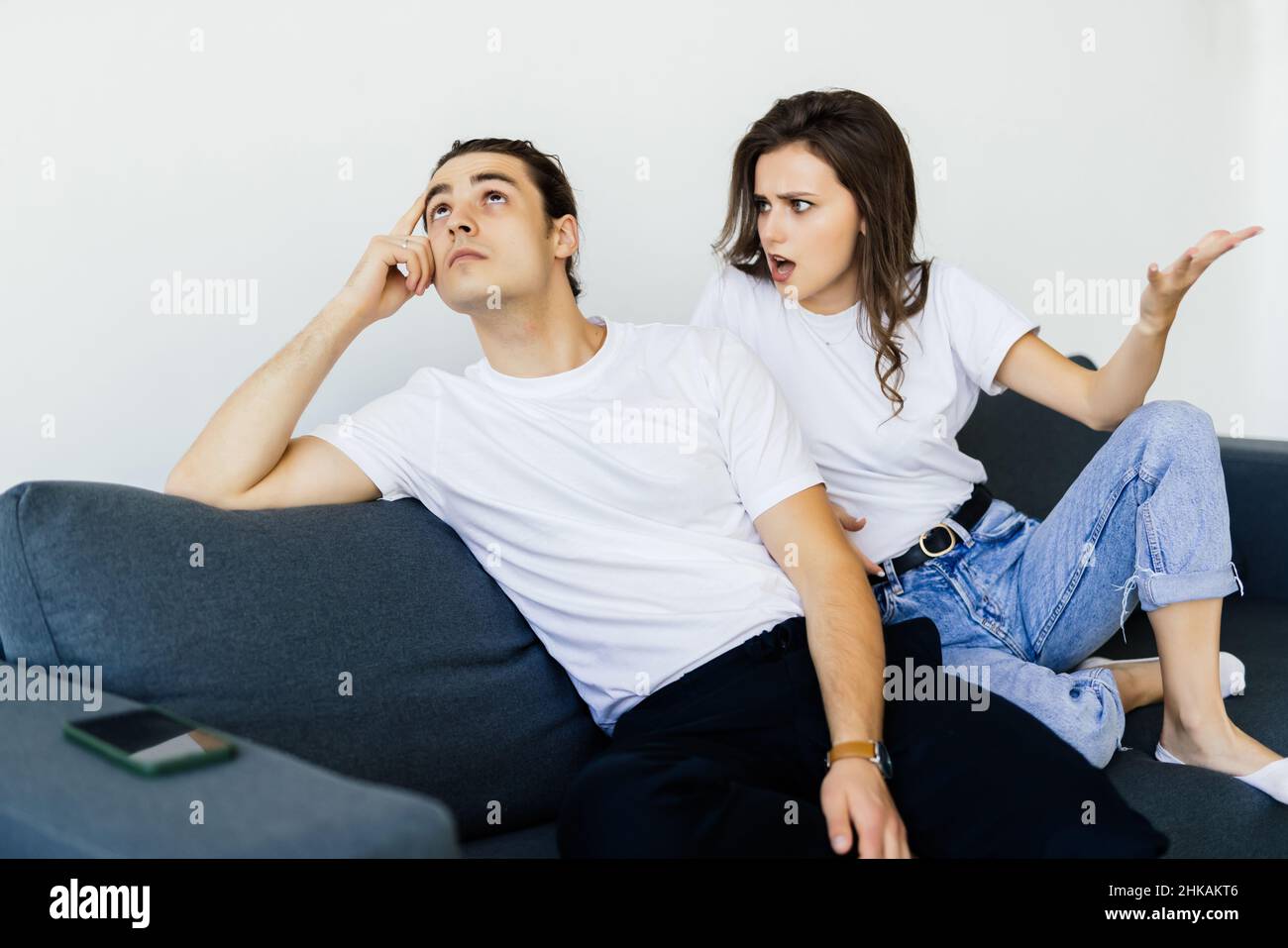 Young couple is having a quarrel while sitting on sofa at home Stock ...