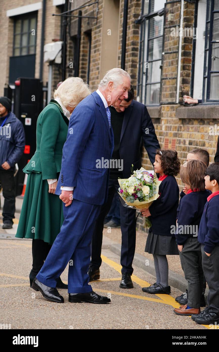 The Prince of Wales and the Duchess of Cornwall speak to pupils from the Faraday School as they leave following a visit to The Prince's Foundation's Trinity Buoy Wharf, a training site for arts and culture in London. Picture date: Thursday February 3, 2022. Stock Photo