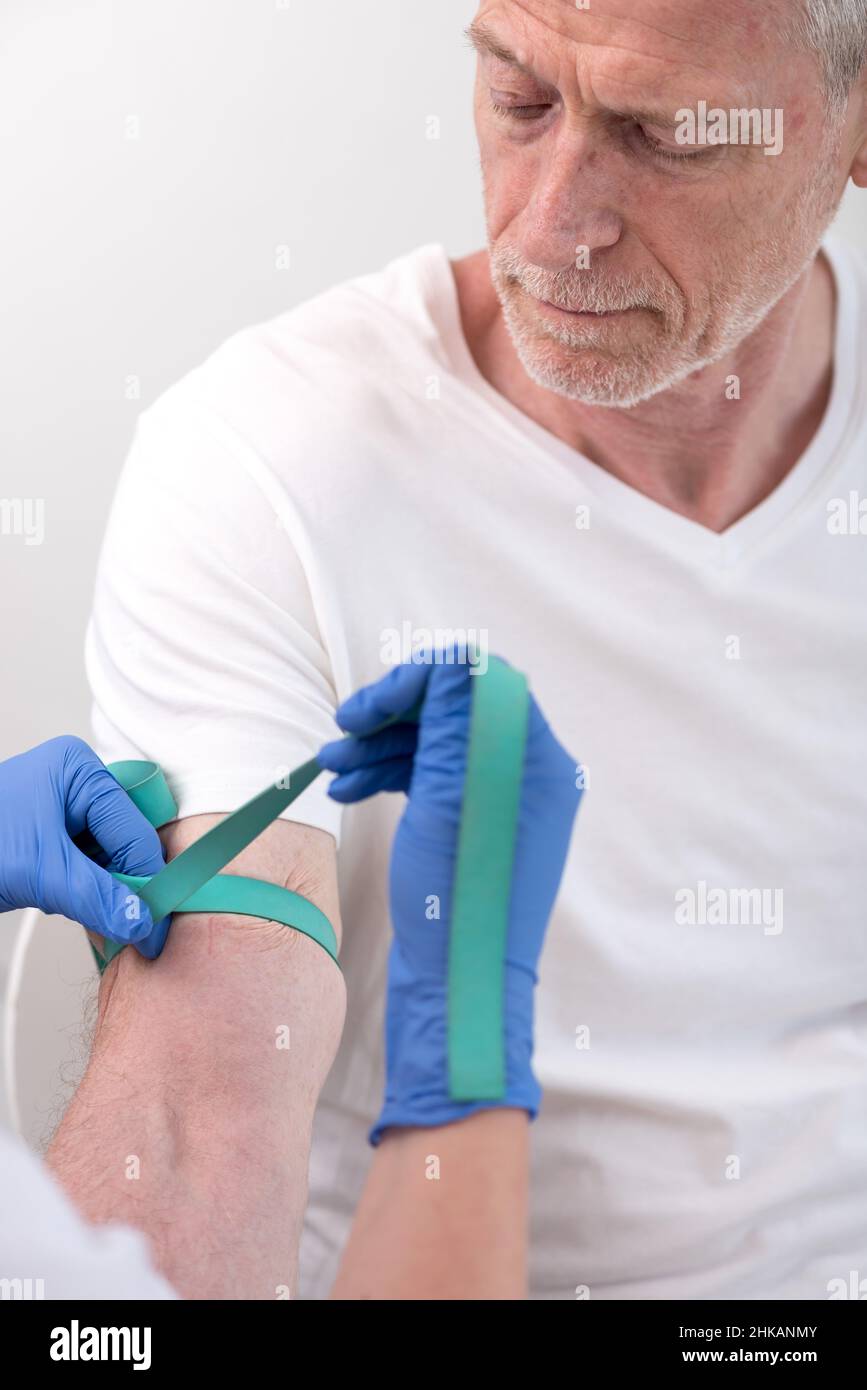 Putting a tourniquet on the arm of a patient before an injection Stock