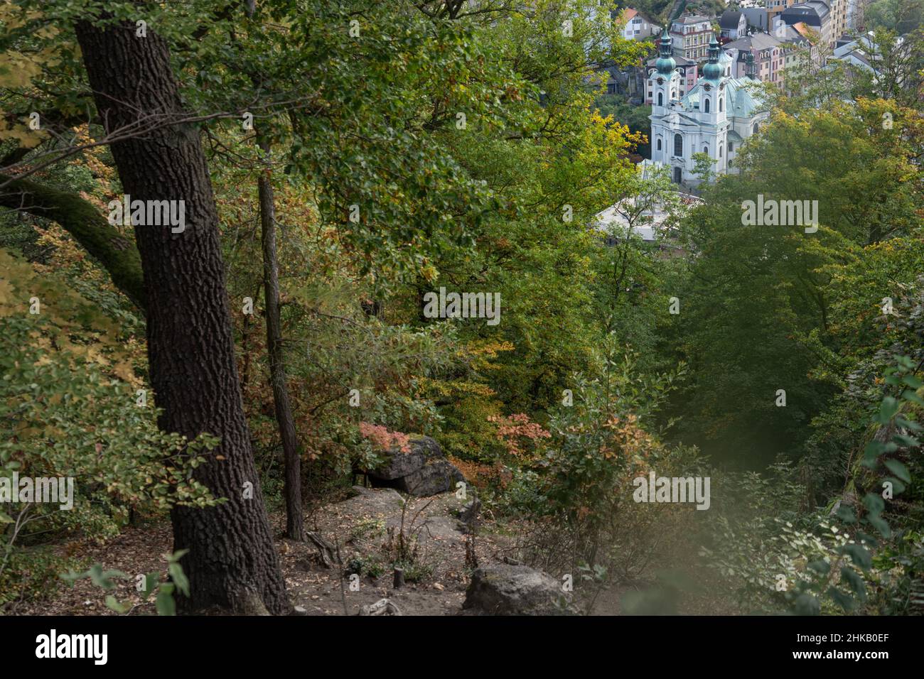 Karlovy Vary (Karlsbad) in Czech Republic: view from the Krystina lookout through a clearing in the trees at the church of Saint Mary Magdalene Stock Photo