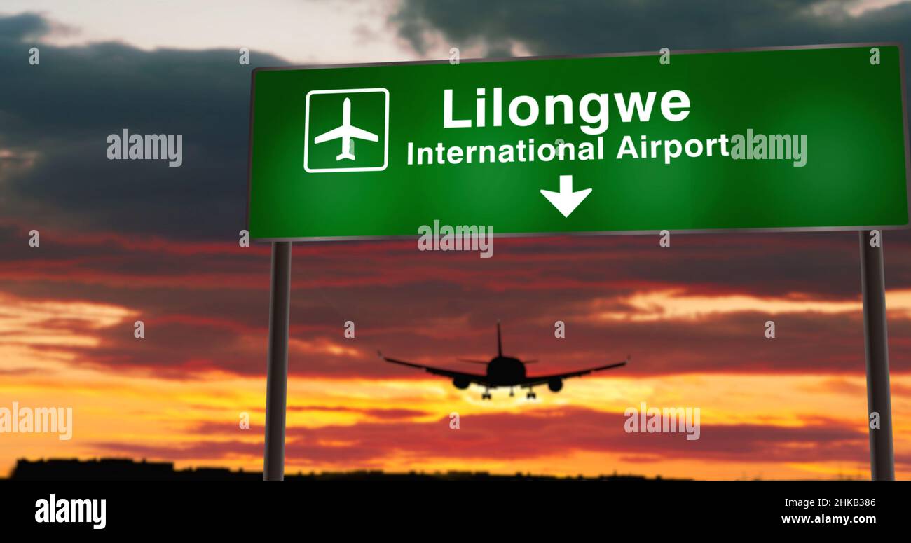 Airplane silhouette landing in Lilongwe, Malawi. City arrival with airport direction signboard and sunset in background. Trip and transportation conce Stock Photo