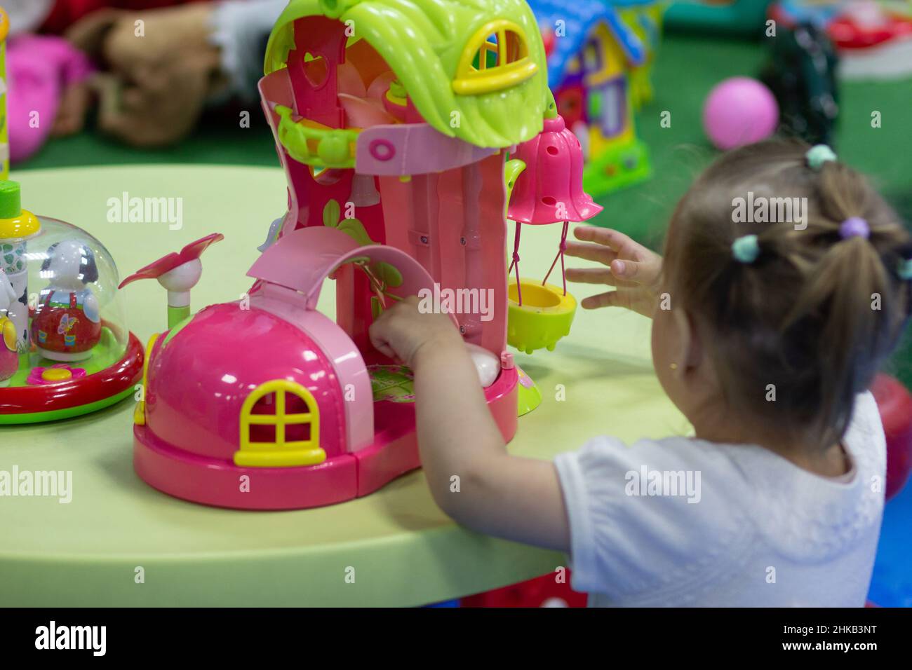 Little girl playing with toys in game room Stock Photo - Alamy