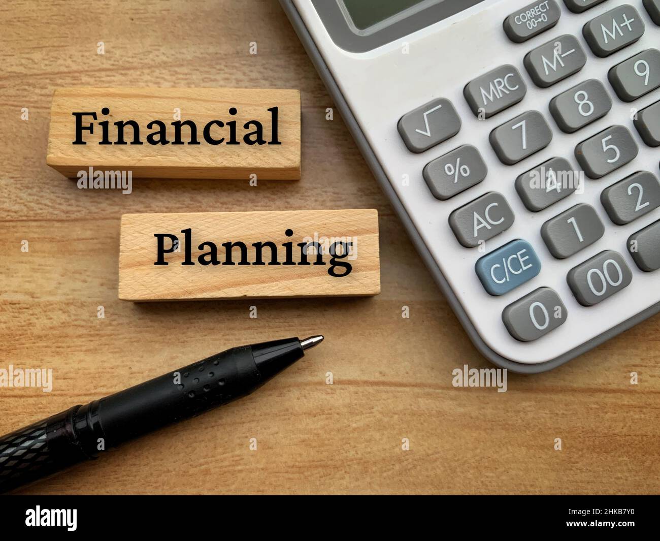 Financial planning text on wooden blocks with calculator and pen background. Stock Photo
