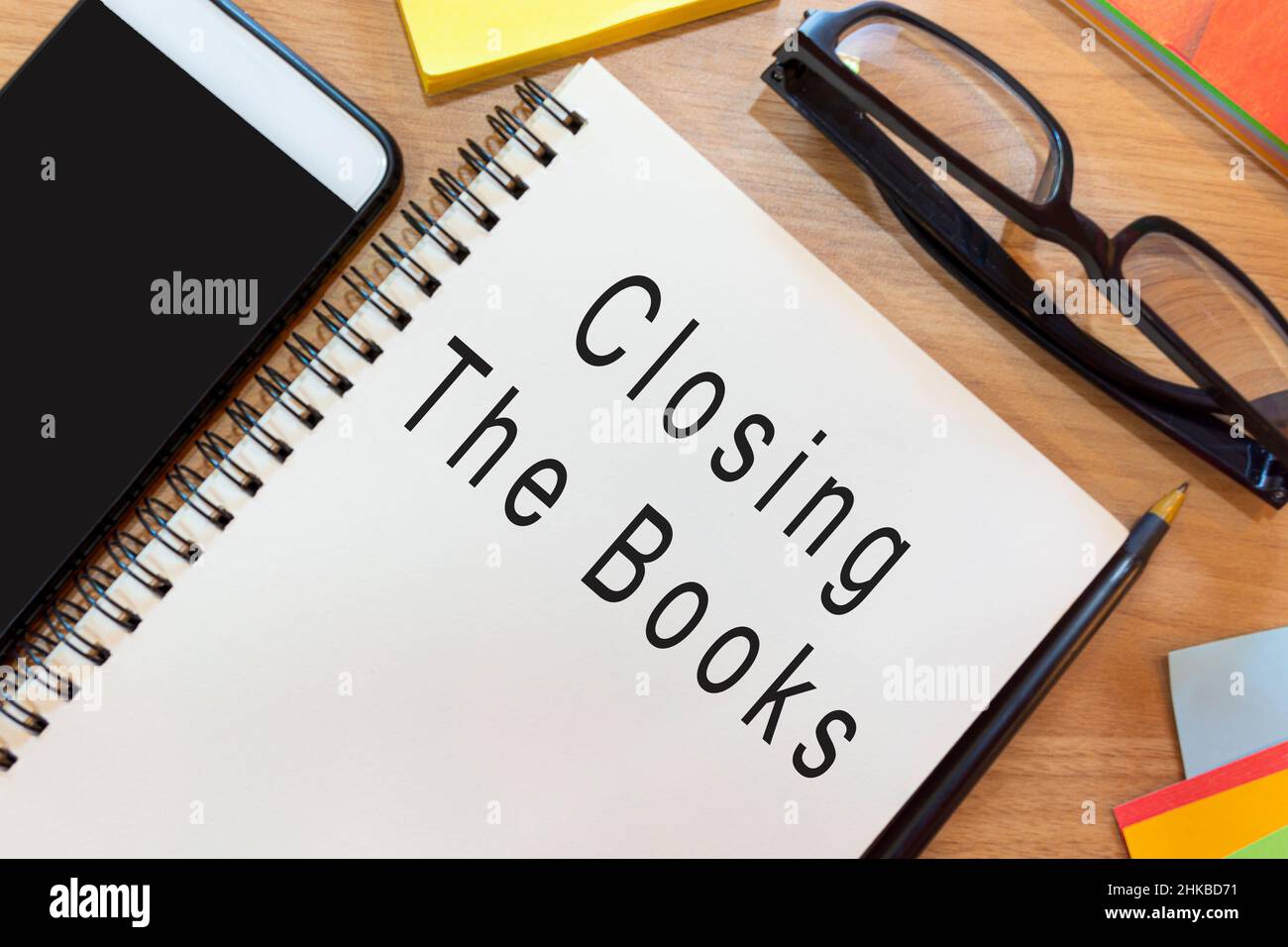 Text on notepad on wooden desk Closing the books. Business and