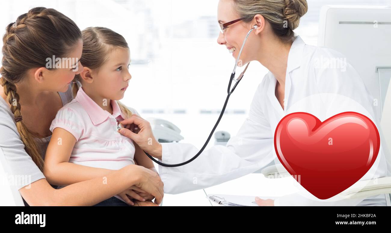Caucasian mid adult female doctor checking caucasian girl sitting with caucasian young mother Stock Photo
