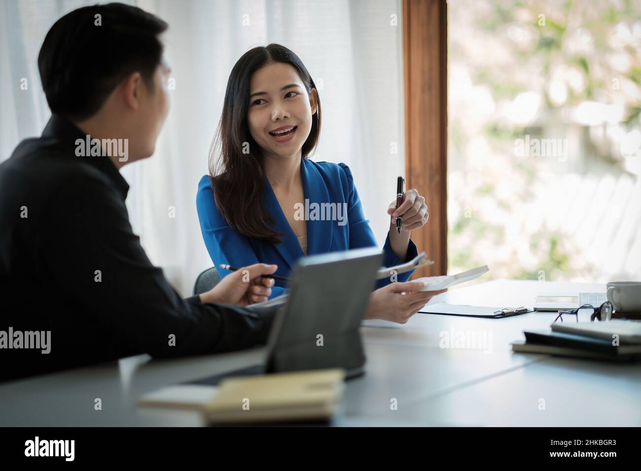 Two business asian Talking Discussing with coworker planning analyzing financial document data charts and graphs in Meeting and successful teamwork Stock Photo