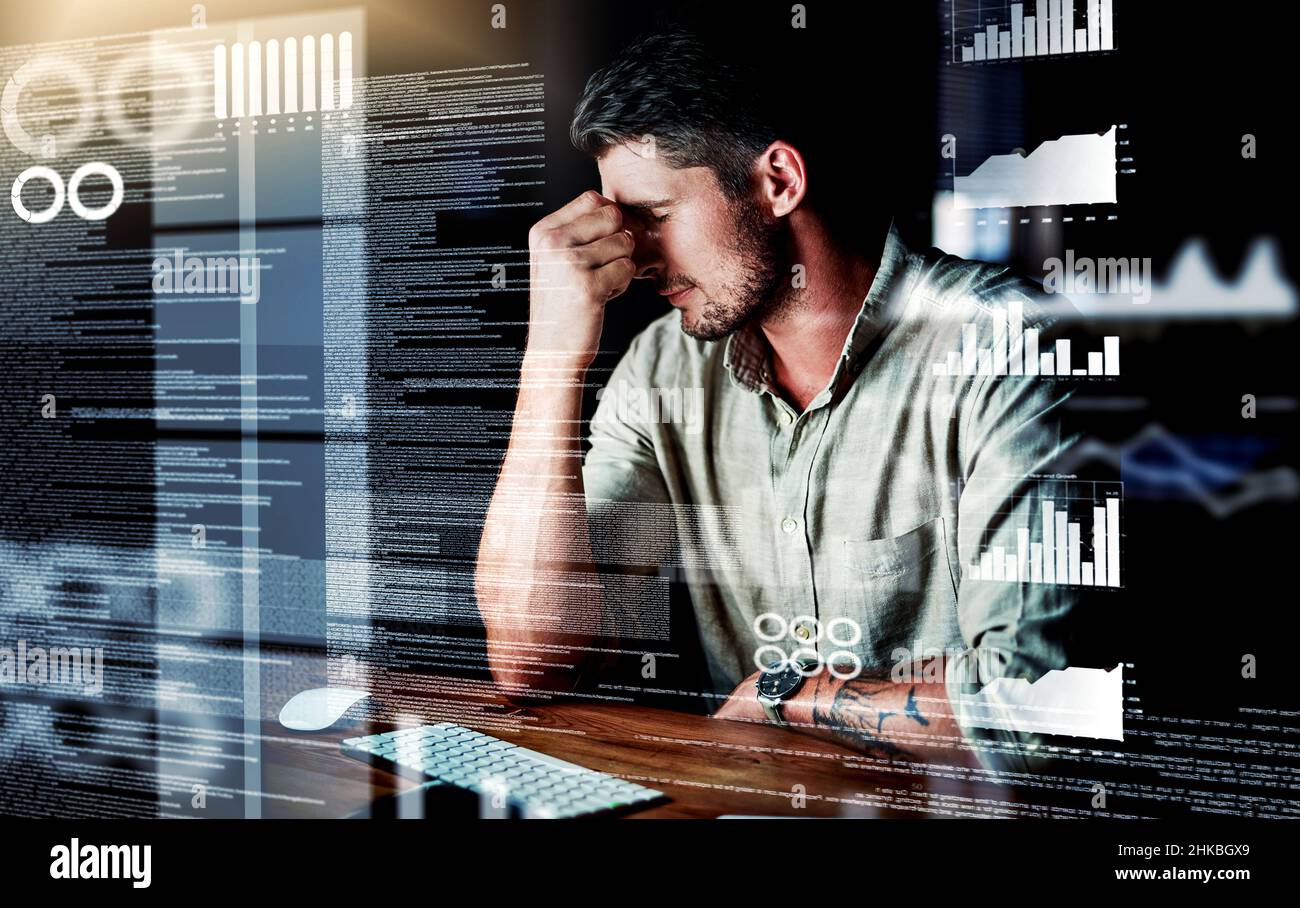 He's just too overwhelmed. Shot of a programmer looking stressed out while working on a computer code at night. Stock Photo