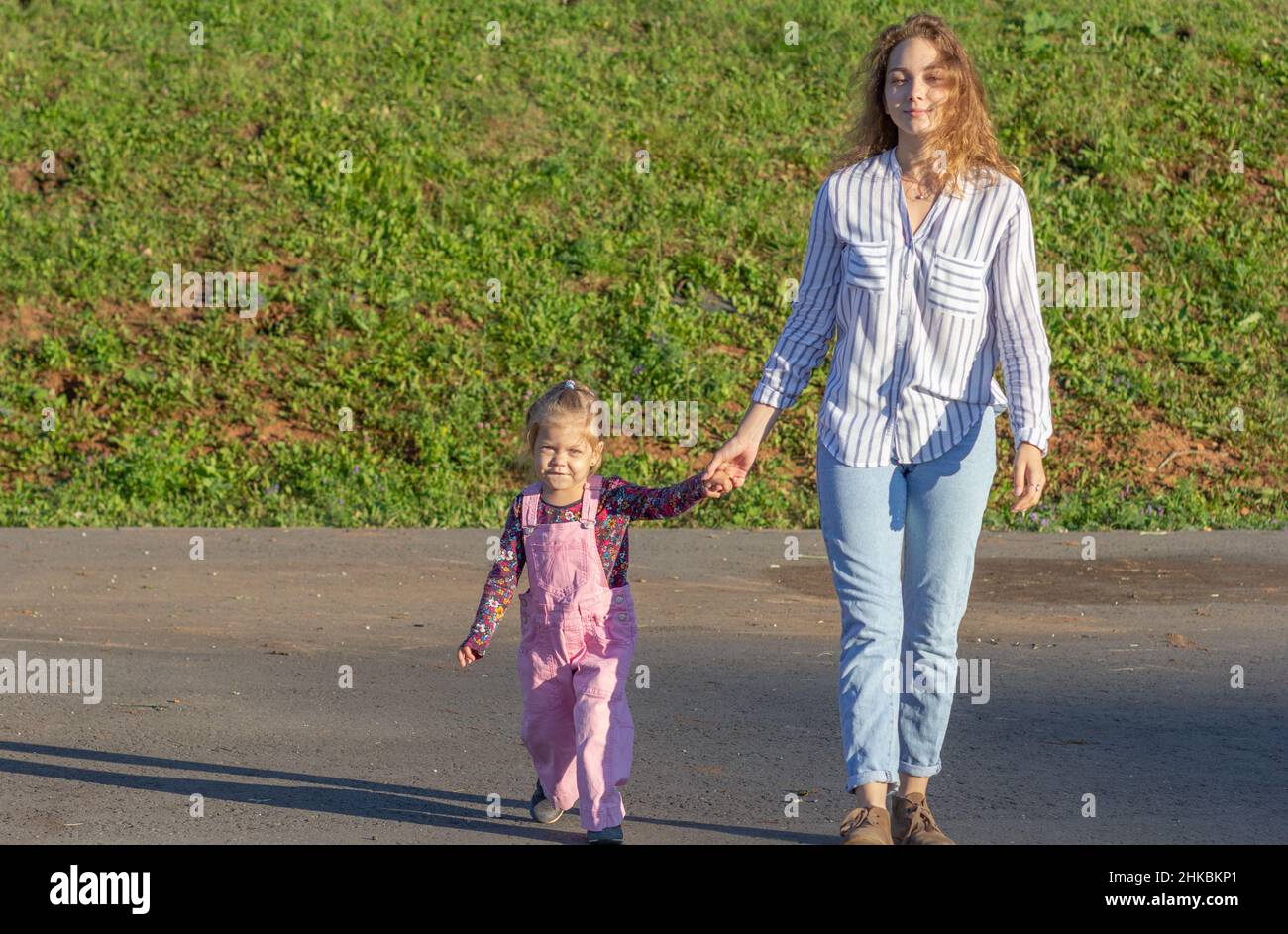 Happy young woman walking on road holding hands Stock Photo - Alamy