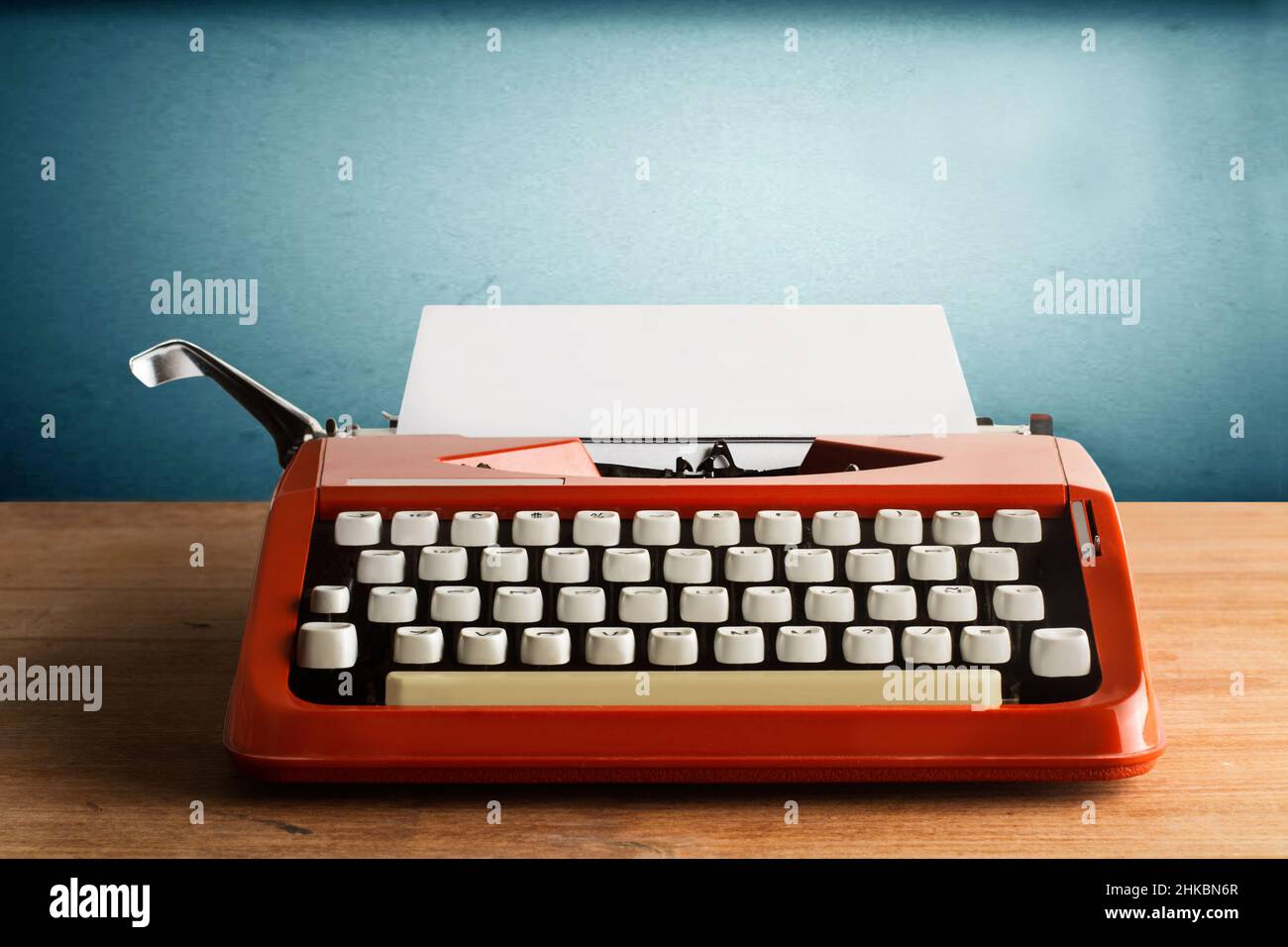 A typewriter whith a sheet of paper on a wooden desk Stock Photo