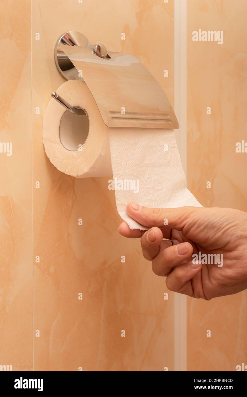 man's hand tears off a piece of toilet paper in the toilet. High quality photo Stock Photo Alamy