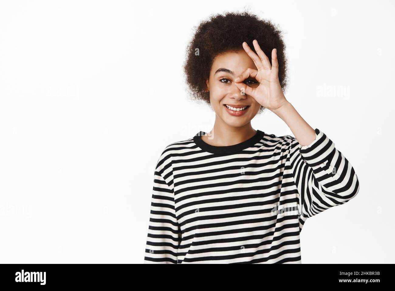 Portrait of smiling african girl showing okay, zero gesture on eye ...