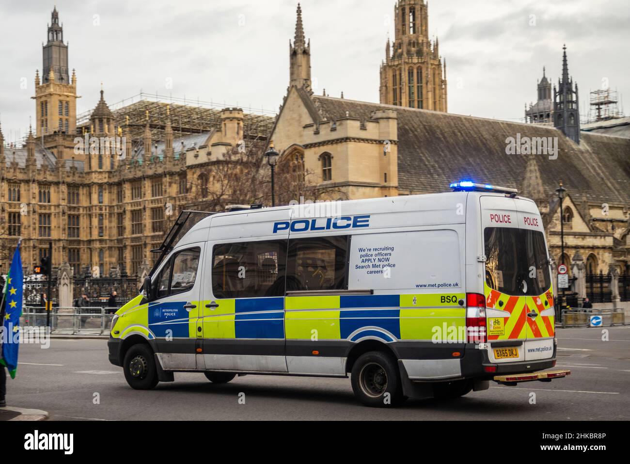 Police van passing the Houses of Parliament, Westminster, London, UK with blue lights. Responding Stock Photo