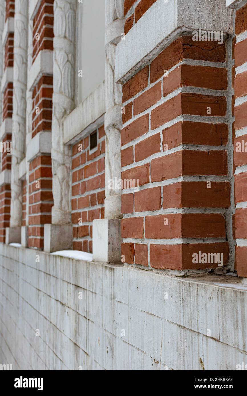 fragment of a red brick wall in winter with columns Stock Photo