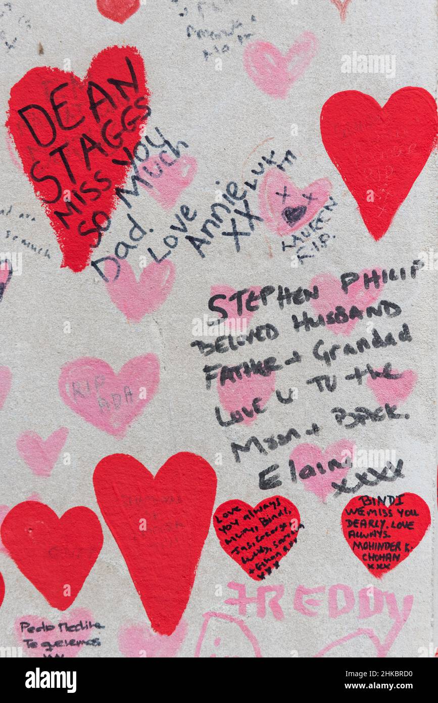 National Covid Memorial Wall in Lambeth, London, UK. Red hearts drawn onto a wall representing each death from COVID 19, with added names. Dad. Love Stock Photo