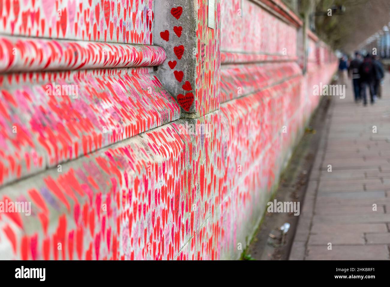 National Covid Memorial Wall on a grim overcast day in Lambeth, London, UK. Red hearts drawn onto a wall representing each death from COVID 19. Length Stock Photo