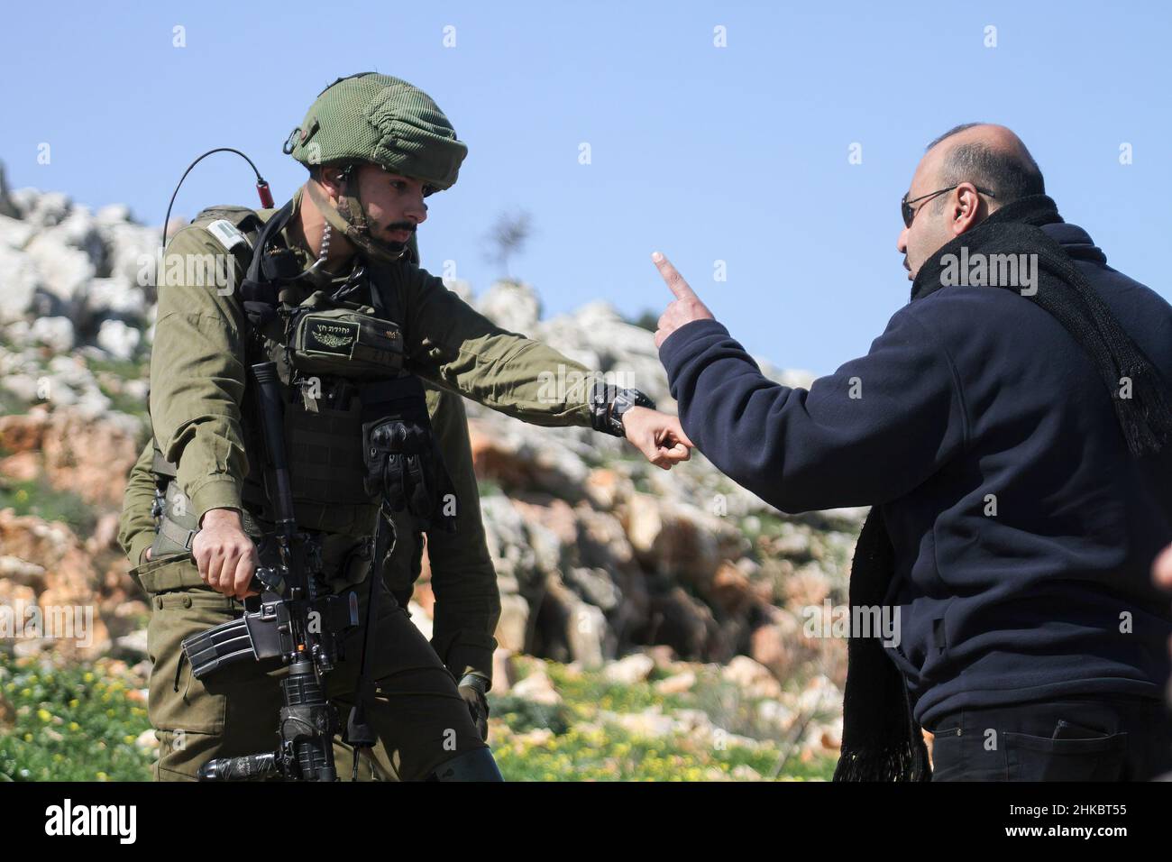 Salfit, Palestine. 03rd Feb, 2022. An Israeli soldier argues with a  Palestinian citizen as they plant olive trees in land seized by settlers  from the Jewish settlement of Ariel near the Salfit