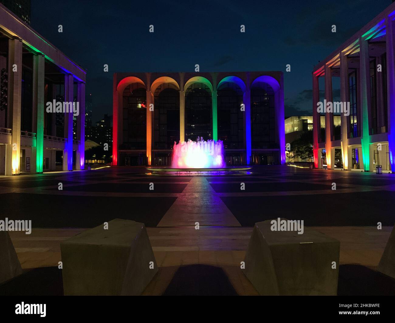 Rainbow colored lights illuminating the colonnade of Lincoln Center in New York City Stock Photo