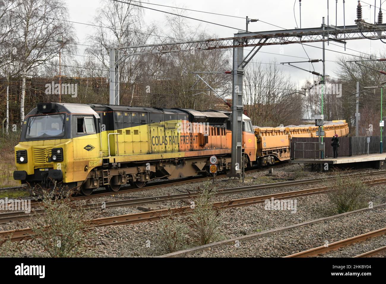 Colas Rail liveried Class 70 number 70815 working a Mountsorrel Tarmac to Carlisle New Yard ballast train joins the WCML at Lichfield Trent Valley Stock Photo