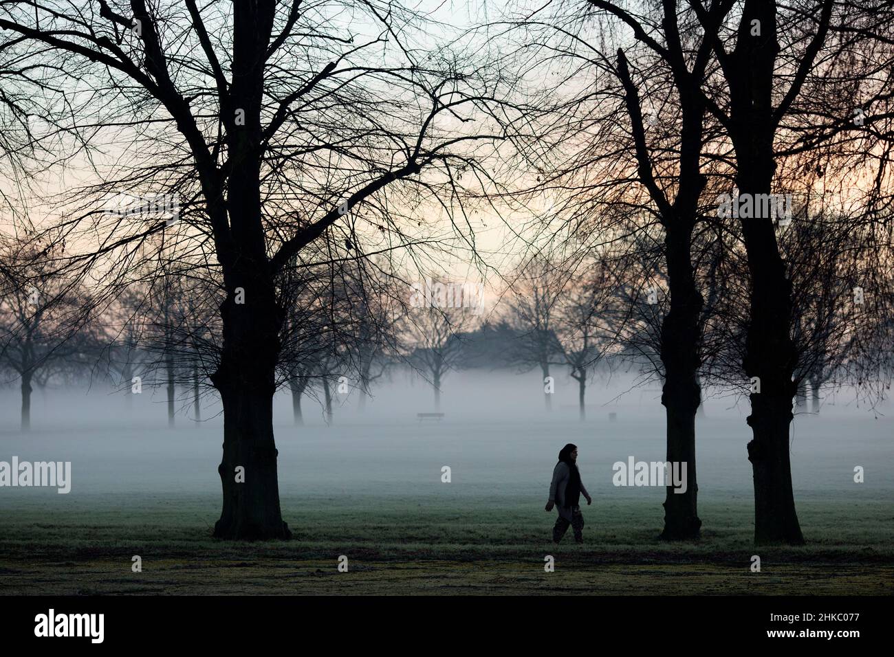 Pedestrians walk in a mistcovered park in Ilford, East London, in the