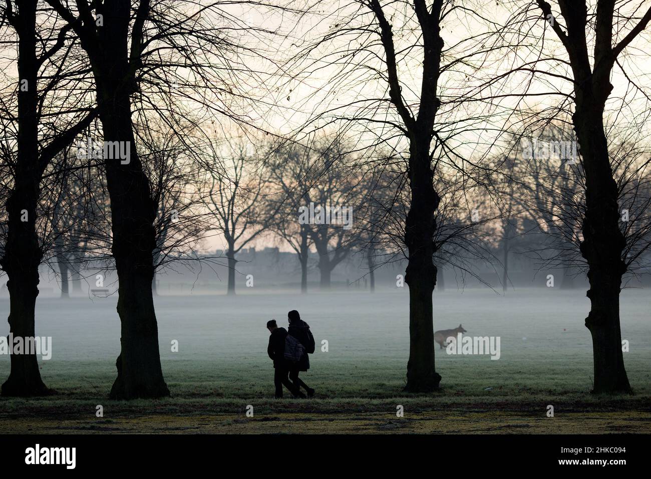 Pedestrians walk in a mistcovered park in Ilford, East London, in the