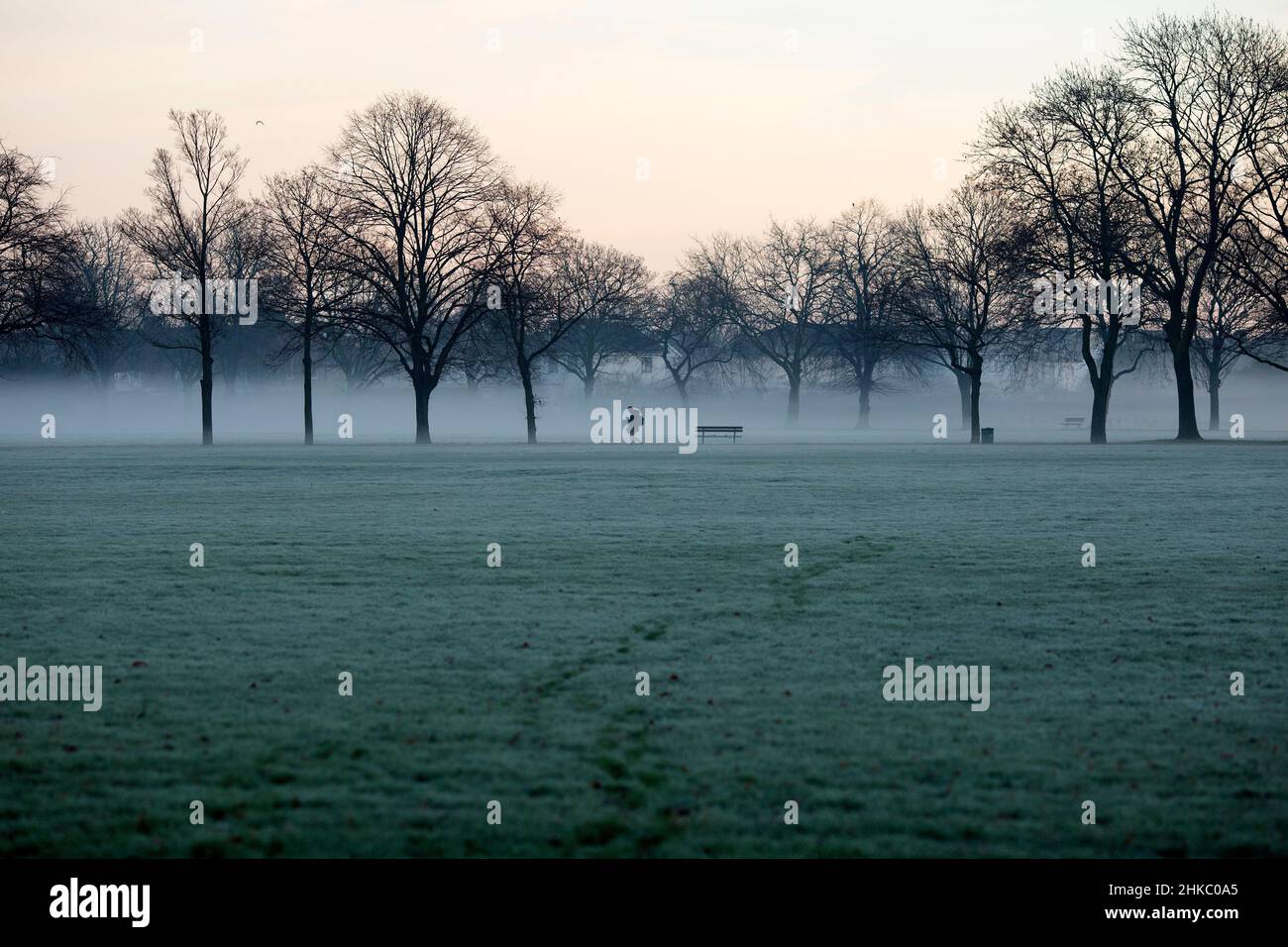 Pedestrians walk in a mistcovered park in Ilford, East London, in the