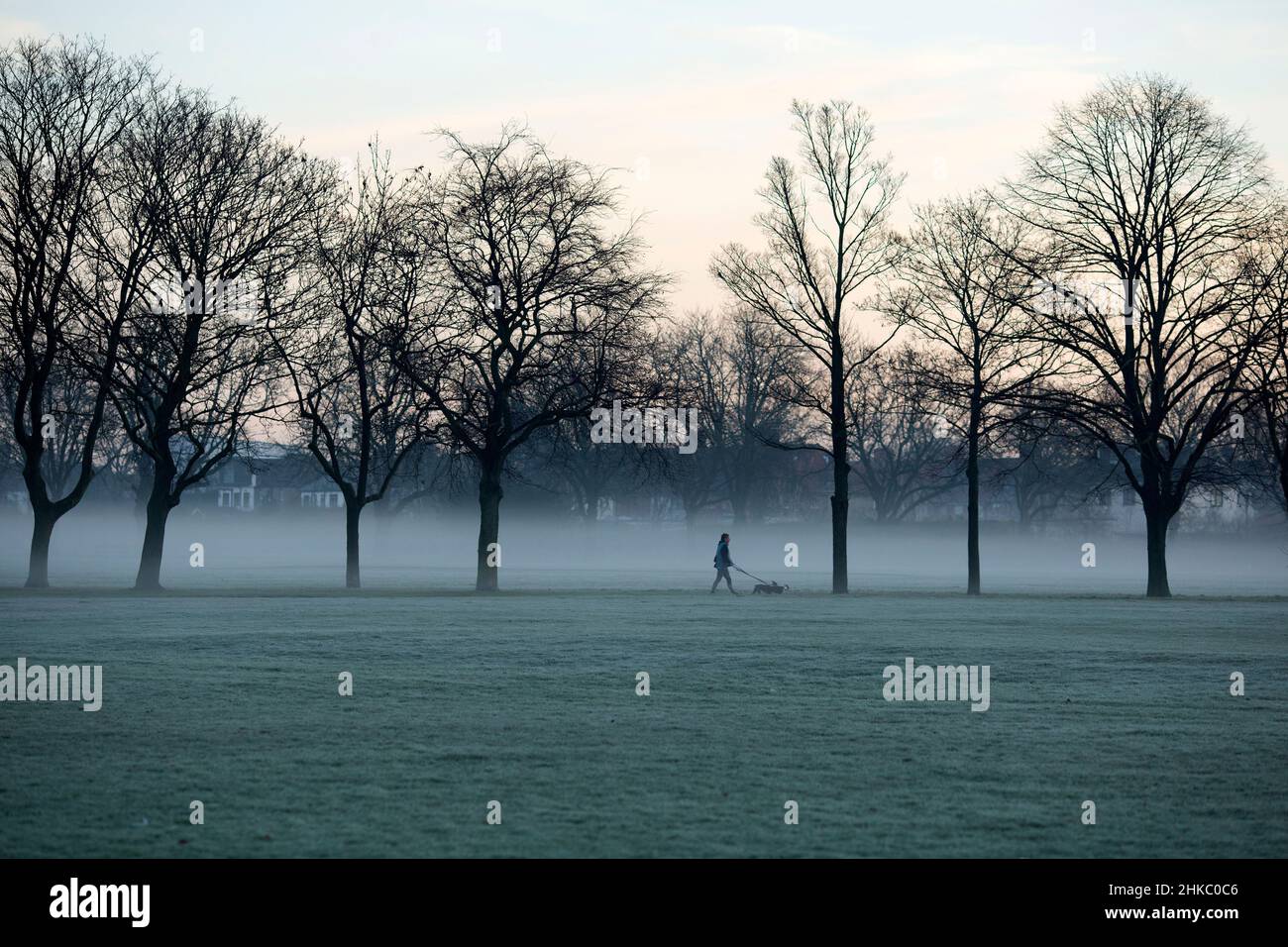 Pedestrians walk in a mistcovered park in Ilford, East London, in the