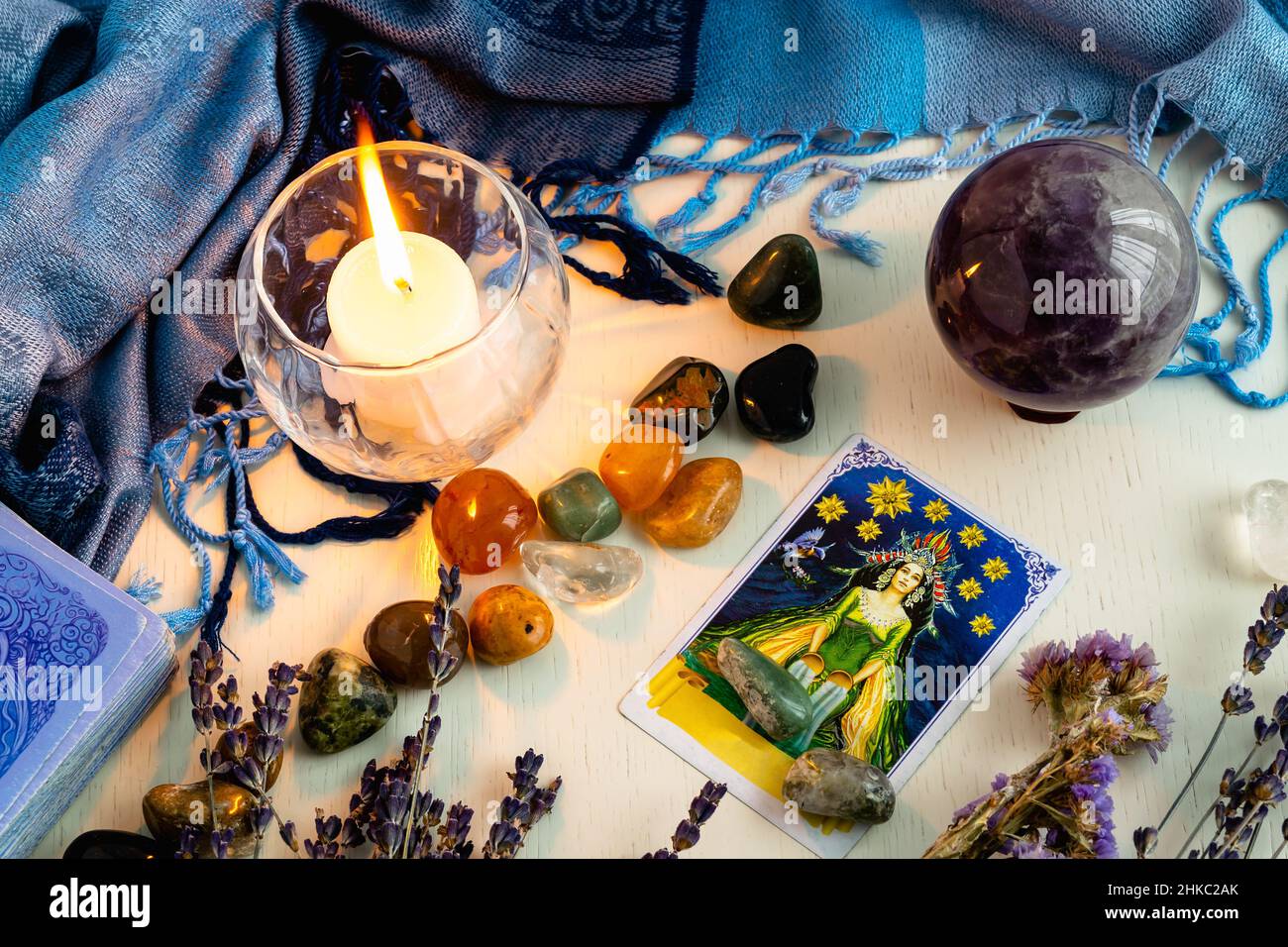Minsk, Belarus - February 2022: star cards in tarot divination with candles and stones on a light table with dried flowers and a blue tablecloth. Magi Stock Photo