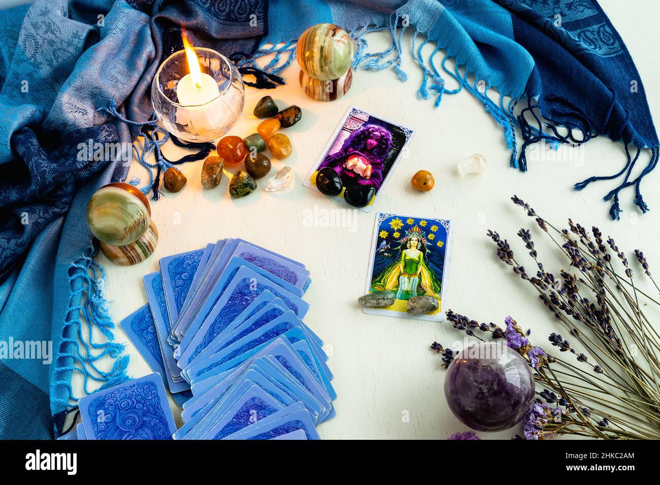 Minsk, Belarus - February 2022: star and priestess cards in tarot divination with candles and stones on a light table with dried flowers and a blue ta Stock Photo