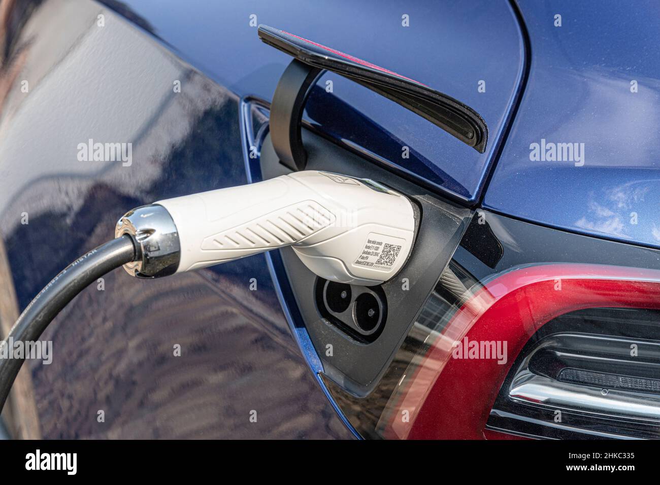 A charging power lead cable plugged in to a Tesla car Stock Photo