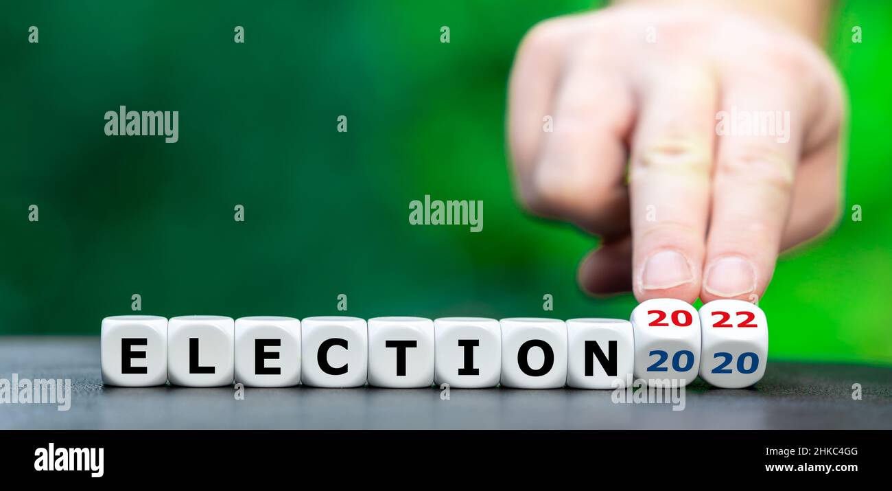 Symbol for the midterm election 2022 in the United States. Hand turns dice and changes the expression 'election 2020' to 'election 2022'. Stock Photo