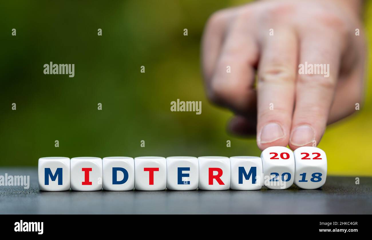 Symbol for the midterm election 2022 in the United States. Hand turns dice and changes the expression 'midterm 2018' to 'midterm 2022'. Stock Photo